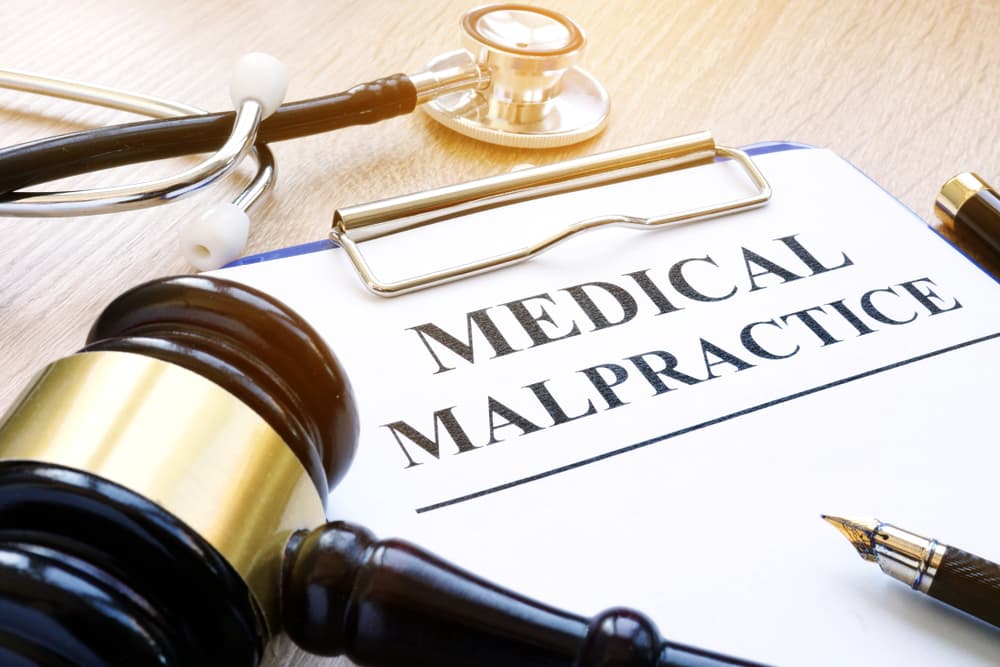 Medical malpractice legal concept showing judge gavel, stethoscope, and document labeled medical malpractice representing negligence and injury claims