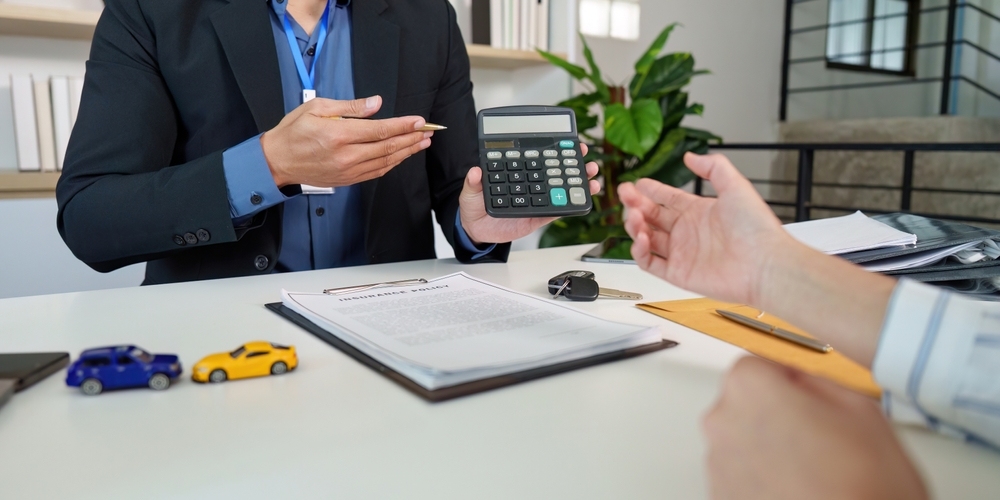 Paperwork and calculator used to evaluate a car accident settlement in Maryland